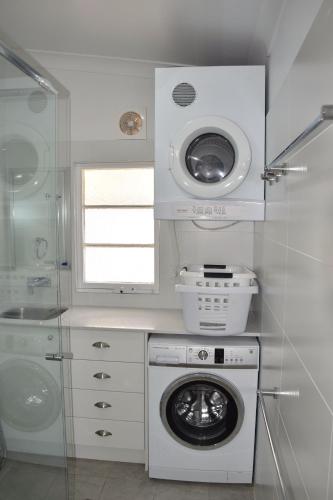 a laundry room with a washing machine and a window at Christina Cottage - Bring your own linen in South West Rocks