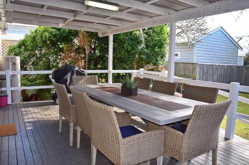 ein Holztisch und Stühle auf einer Terrasse in der Unterkunft Christina Cottage - Bring your own linen in South West Rocks