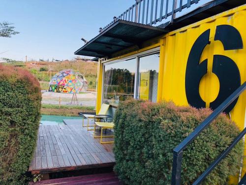 a yellow house with a deck with a playground at Chick Resort Khao Kho in Khao Kho