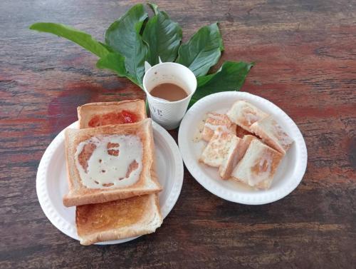 two white plates with toast and a cup of coffee at Keangvarin Resort in Ban Kaeng Manao