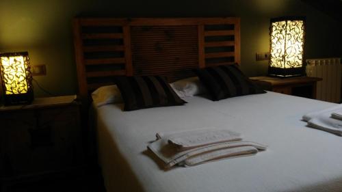 ein Schlafzimmer mit einem Bett mit Handtüchern darauf in der Unterkunft La Casona de Palu in Pola de Laviana