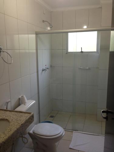 a bathroom with a shower with a toilet and a sink at Hotel Notre Dame in Luís Eduardo Magalhães