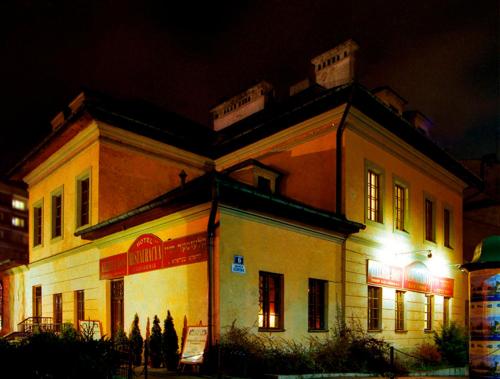 a large building with lights in front of it at night at Austeria Klezmer Hois in Krakow