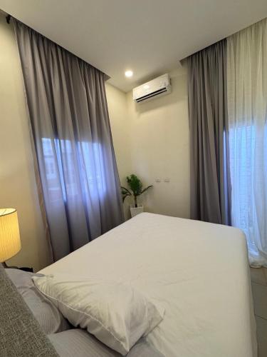 a bedroom with a white bed and a window at Casa cómoda cerca Aeropuerto Palmerola fácil acceso in Comayagua