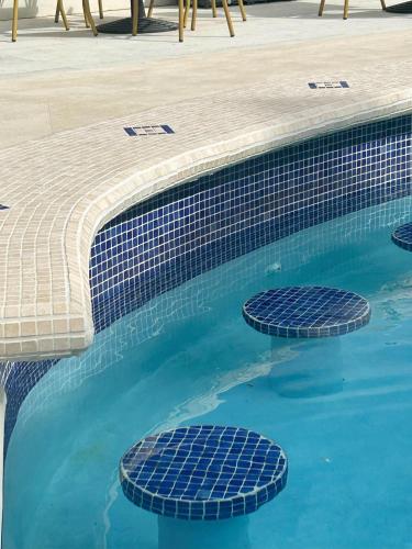 a swimming pool with blue water and blue tiles at South Point Hotel Inc in Christ Church