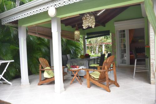 a patio with chairs and a table on a porch at Gite d'Arles Bungalow "Orchidée" in Le Moule