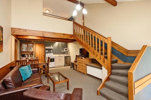 a living room with a staircase and a kitchen at Balmoral Lodge Motel in Invercargill