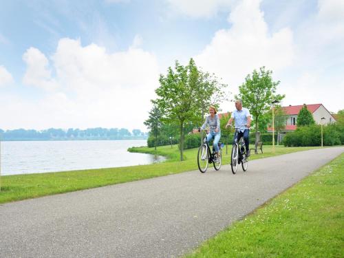 two people riding bikes down a road next to a lake at Pet-Friendly Getaway in Heel