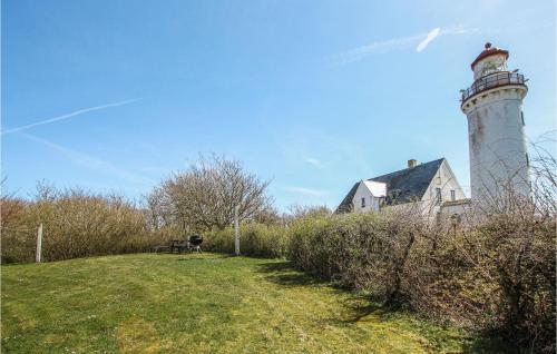 a lighthouse on a hill next to a house at Stunning Apartment In Samsø With Wifi in Kolby Kås