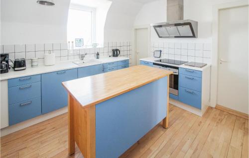 a kitchen with blue cabinets and a wooden counter top at Stunning Apartment In Samsø With Wifi in Kolby Kås