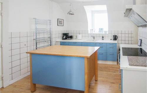 a kitchen with blue cabinets and a blue island at Stunning Apartment In Samsø With Wifi in Kolby Kås