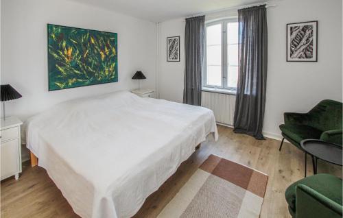 a white bedroom with a large bed and a chair at Stunning Apartment In Samsø With Wifi in Kolby Kås