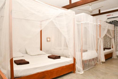 a bedroom with a bed with mosquito nets at Arne's Place in Arugam Bay