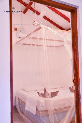 a bedroom with a bed with a net at Arne's Place in Arugam Bay