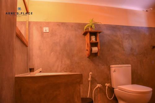 a bathroom with a toilet and a sink at Arne's Place in Arugam Bay