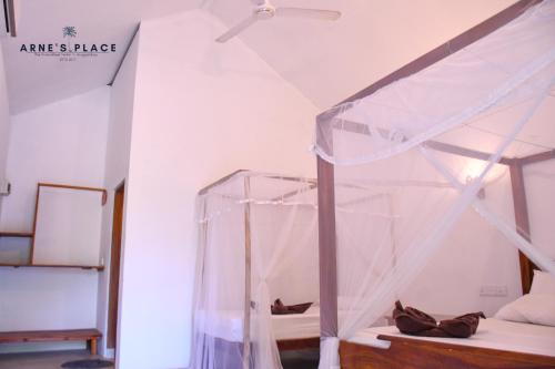 a bedroom with a bed with a canopy at Arne's Place in Arugam Bay