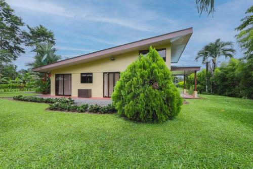 a house with a bush in front of it at La Casa Amarilla in Fortuna