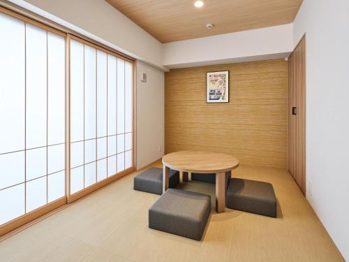 a small room with a table and two stools at MIMARU Tokyo Kinshicho in Tokyo