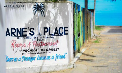 a wall with a sign on the side of a street at Arne's Place in Arugam Bay