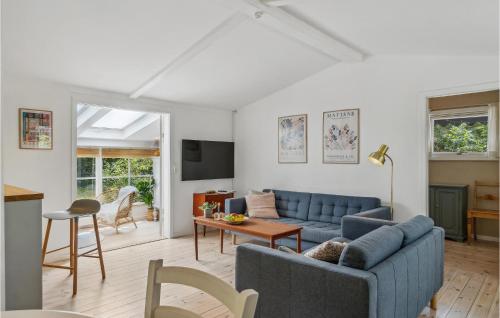 a living room with a blue couch and a table at 2 Bedroom Amazing Home In Nexø in Neksø