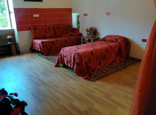 een slaapkamer met een rood bed en een bank bij La Meridiana Bed & Bike in Celico