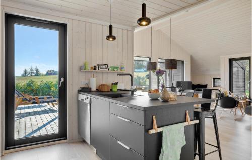 a kitchen with a sink and a large window at Lovely Home In Allinge With Wifi in Allinge