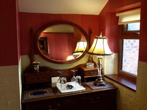 a bathroom with a mirror and a table with a lamp at The Lonsdale in Blackpool