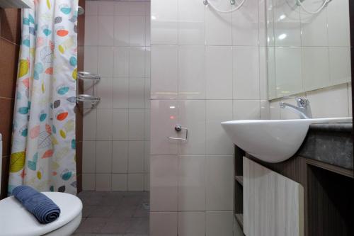 a bathroom with a sink and a toilet and a shower at Clean and Cozy 1BR Apartment with Sofabed at Atlanta Residences By Travelio in Depok
