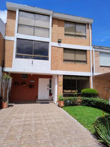 a brick house with a driveway in front of it at Casa Café & Orquídea - Hospedaje in Bogotá