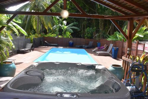 a jacuzzi tub in a backyard with a pool at Gites d'Arles Bungalow T1 BIS in Le Moule