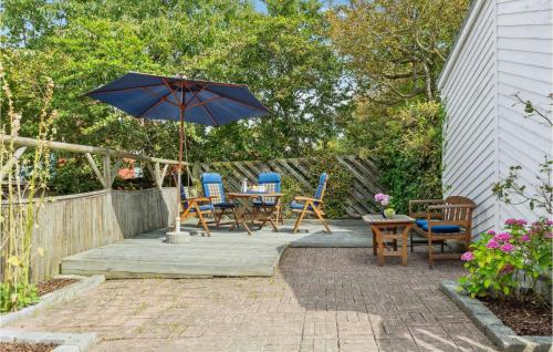 a patio with a table and chairs and an umbrella at 2 Bedroom Lovely Home In Rudkøbing in Rudkøbing