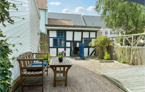 a patio with two chairs and a table and a house at 2 Bedroom Lovely Home In Rudkøbing in Rudkøbing