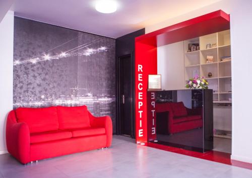 
a red couch sitting in a living room next to a red wall at Pension Santa Fe in Suceava
