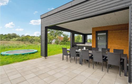 a patio with a table and chairs and a pool at Awesome Home In Løgstrup With Kitchen in Løgstrup