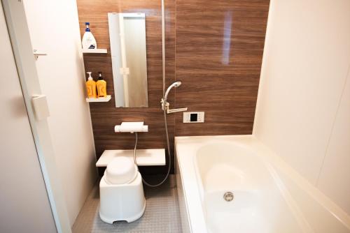 a bathroom with a tub and a toilet and a sink at 太宰府 月光の宿 MoonLight inn Free parking 4LDK一軒家 駐車場2台付き in Dazaifu