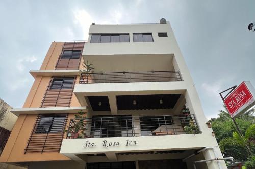 a building with a sign that reads she loves him at Sta Rosa Inn Iloilo powered by Cocotel in Iloilo City