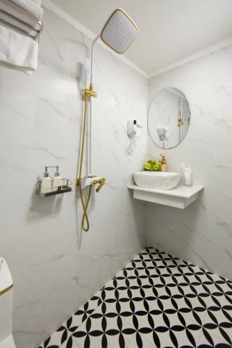 a bathroom with a black and white tiled floor at Dream Premium Hotel & Spa in Hanoi