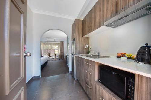 a kitchen with a sink and a counter top at Hamilton's Queanbeyan Motel in Queanbeyan