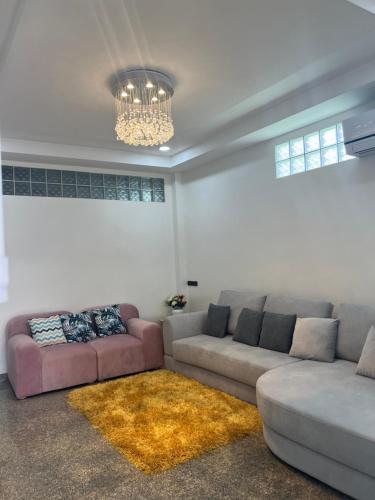 a living room with two couches and a chandelier at Pani House Hatyai 5 in Hat Yai