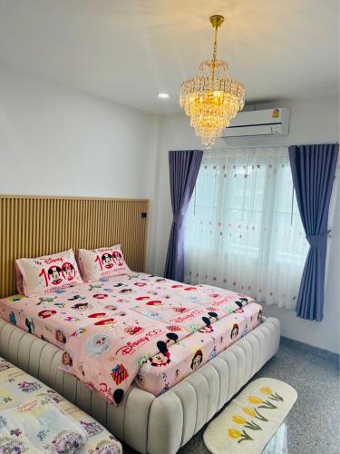 a bedroom with two beds and a chandelier at Pani House Hatyai 5 in Hat Yai