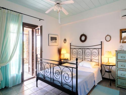 a bedroom with a bed with a wrought iron headboard at Stunning seafront apartment in Kea in Korissia