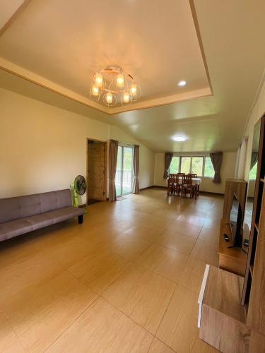 an empty living room with a couch and a table at Siam Butterfly Farm in Ban Huai Salok