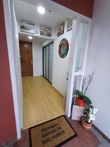 a hallway with a door and a rug at Casa Café & Orquídea - Hospedaje in Bogotá