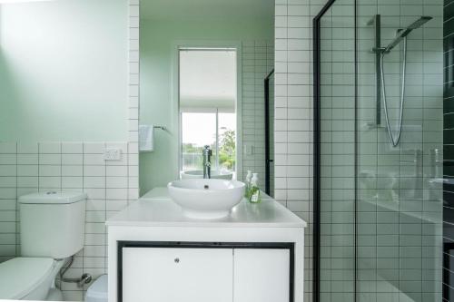 a bathroom with a sink and a toilet and a shower at Newly built with WiFi & Healthclub, pool & gym access in Inverloch