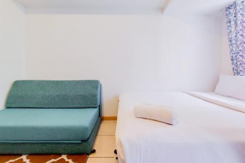 タンゲランにあるStrategic and Nice Studio Apartment at M-Town Residence Travelioのベッド1台、緑と白のソファが備わる客室です。