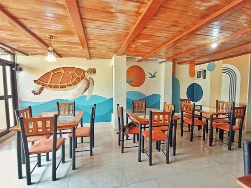 a dining room with a turtle mural on the wall at Hotel Rodadero Relax in Gaira