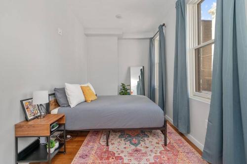 a bedroom with a bed and a table and a window at Prime OTR off Vine St, Lux Full Bed, Fast WiFi, Fully Equipped, 50in TV, Sleeps 4ppl in Cincinnati
