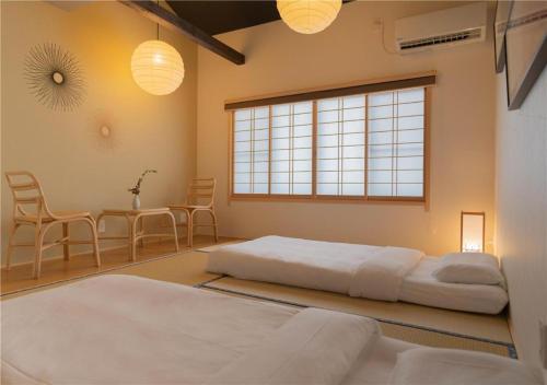 京都市にある谷町君・星屋・秋の家のベッドとテーブルと椅子のある寝室