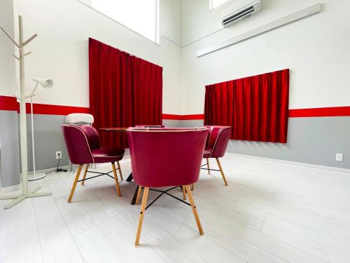 a room with red curtains and a table and chairs at Tomato Cube in Asahikawa