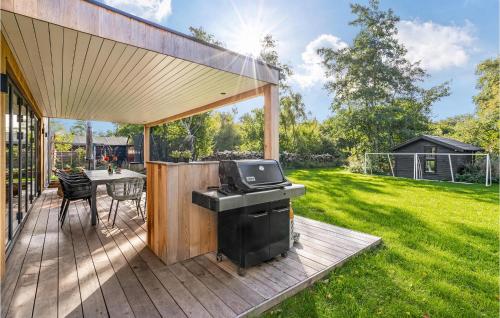 a patio with a grill and a table in a yard at Beautiful Home In Sjællands Odde With 5 Bedrooms in Yderby